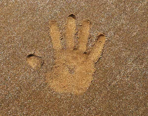 impronta di una mano nella sabbia
